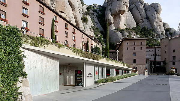 The entrance in front of a mountainous background.